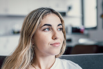 Head shot close up dreamy young smiling beautiful woman looking away, visualizing future indoors of recollecting good memories. Happy healthy millennial girl enjoying free weekend time at home..