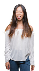 Fototapeta premium Young asian woman over isolated background winking looking at the camera with sexy expression, cheerful and happy face.