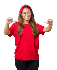 Young beautiful brunette woman wearing red t-shirt over isolated background looking confident with smile on face, pointing oneself with fingers proud and happy.