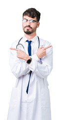 Fototapeta premium Young doctor man wearing hospital coat over isolated background Pointing to both sides with fingers, different direction disagree