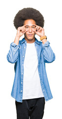 Young african american man with afro hair Trying to open eyes with fingers, sleepy and tired for morning fatigue