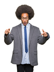 Young african american business man with afro hair wearing glasses Pointing down with fingers showing advertisement, surprised face and open mouth