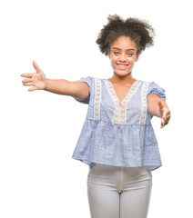 Young afro american woman over isolated background looking at the camera smiling with open arms for hug. Cheerful expression embracing happiness.