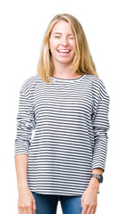 Beautiful young woman wearing stripes sweater over isolated background winking looking at the...
