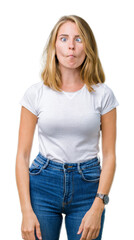 Beautiful young woman wearing casual white t-shirt over isolated background making fish face with lips, crazy and comical gesture. Funny expression.