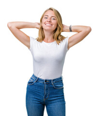 Fototapeta premium Beautiful young woman wearing casual white t-shirt over isolated background Relaxing and stretching with arms and hands behind head and neck, smiling happy
