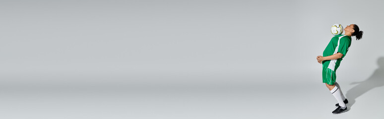 A female athlete in a green jersey juggles a soccer ball with ease.