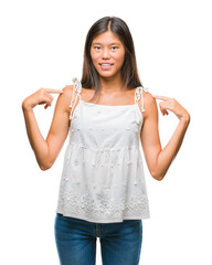 Young asian woman over isolated background looking confident with smile on face, pointing oneself...