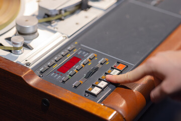 Woman operating vintage tape recorder