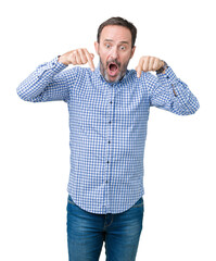 Fototapeta premium Handsome middle age elegant senior man over isolated background Pointing down with fingers showing advertisement, surprised face and open mouth