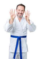 Handsome middle age senior man wearing kimono uniform over isolated background showing and pointing up with fingers number nine while smiling confident and happy.