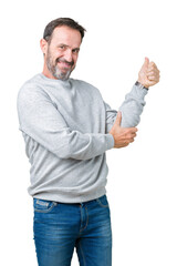 Handsome middle age senior man wearing a sweatshirt over isolated background Looking proud, smiling doing thumbs up gesture to the side