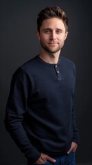 Fototapeta premium A man in a blue sweater smiles for the camera in a studio
