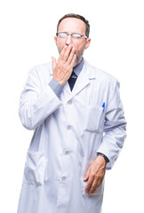 Middle age senior hoary professional man wearing white coat over isolated background bored yawning tired covering mouth with hand. Restless and sleepiness.