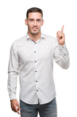 Handsome young business man surprised with an idea or question pointing finger with happy face, number one