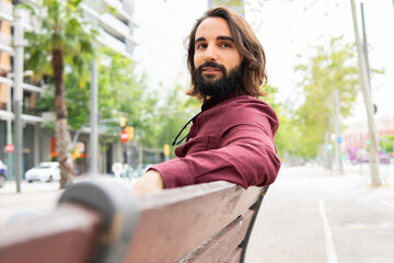 Man relaxing on a bench in Poblenou, embracing urban lifestyle
