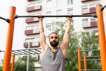 Man exercising on outdoor pull-up bar in Poblenou