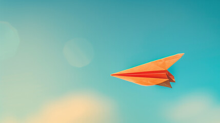 Orange Paper Airplane Soaring Against Blue Sky