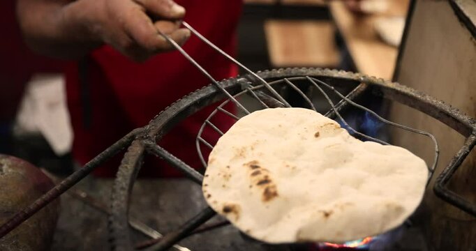 Street food in India. Roti flatbread is made over an open flame on the street. Street food in Asia.