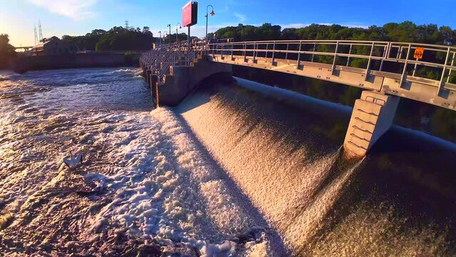 Dawn drone flight over rapids below the waterfall by the dam
