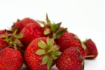 Fresh ripe natural strawberries on a white background. Freshly picked garden strawberries. Detailed photo of strawberries on an abstract background. Close up view.