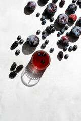 Red fruit juice with blackberries and plums on kitchen countertop