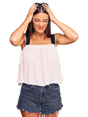 Young hispanic woman wearing casual clothes suffering from headache desperate and stressed because pain and migraine. hands on head.