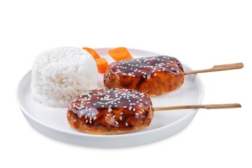 Tsukune, Japanese Chicken Meatball in teriyaki sauce with sesame seeds sprinkles with rice and vegetables in a plate on a white isolated background