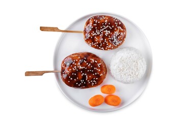 Tsukune, Japanese Chicken Meatball in teriyaki sauce with sesame seeds sprinkles with rice and vegetables in a plate on a white isolated background