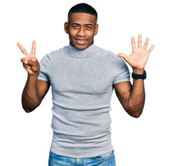 Young black man wearing casual t shirt showing and pointing up with fingers number seven while smiling confident and happy.