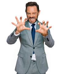 Middle age man wearing business clothes smiling funny doing claw gesture as cat, aggressive and sexy expression