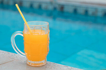 un vaso de zumo de naranja, jugo delicioso ,sol, costado piscina, día caluroso, bebida refrescante, disfrute, bebida