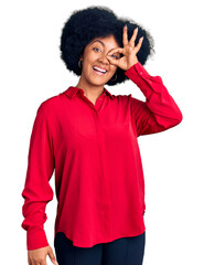 Young african american girl wearing casual clothes doing ok gesture with hand smiling, eye looking through fingers with happy face.