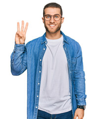 Young caucasian man wearing casual clothes showing and pointing up with fingers number three while...