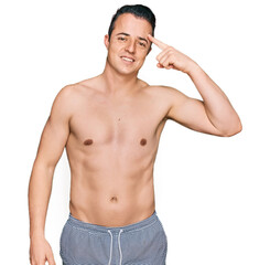 Fototapeta premium Handsome young man wearing swimwear shirtless smiling pointing to head with one finger, great idea or thought, good memory
