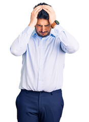 Fototapeta premium Young hispanic man wearing business clothes suffering from headache desperate and stressed because pain and migraine. hands on head.