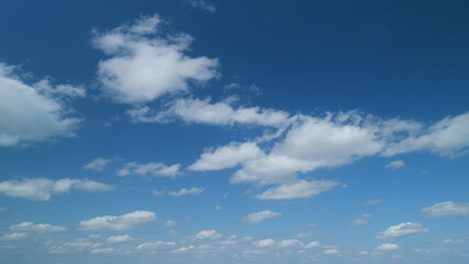 Obraz premium White stratocumulus and cumulus cloudscape on beautiful sunny clear sky. Tropical summer sunlight. Timelapse.