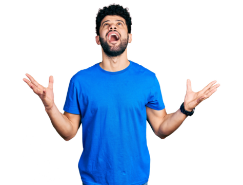 Young arab man with beard wearing casual blue t shirt crazy and mad shouting and yelling with aggressive expression and arms raised. frustration concept.