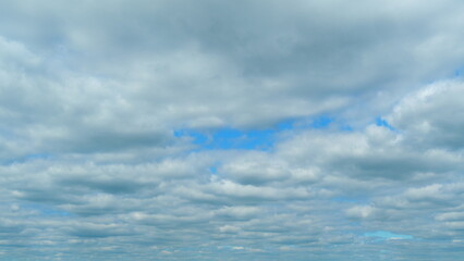 Background of dark dramatic sky with stormy clouds. Moving white puffy clouds on blue sky. Time lapse.