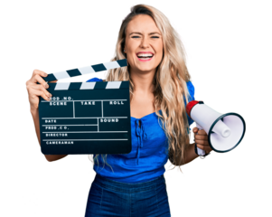Young blonde woman holding video film clapboard and megaphone smiling and laughing hard out loud because funny crazy joke.