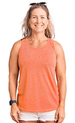 Fototapeta premium Middle age fit blonde woman wearing casual summer clothes and sunglasses with a happy and cool smile on face. lucky person.