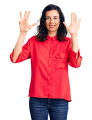 Young beautiful hispanic woman wearing casual clothes showing and pointing up with fingers number...