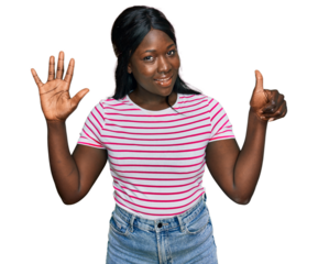 African young woman wearing casual striped t shirt showing and pointing up with fingers number six while smiling confident and happy.