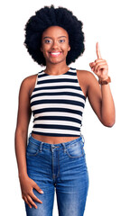 Young african american woman wearing casual clothes pointing finger up with successful idea. exited and happy. number one.