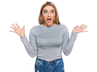 Young caucasian woman wearing casual clothes celebrating victory with happy smile and winner expression with raised hands