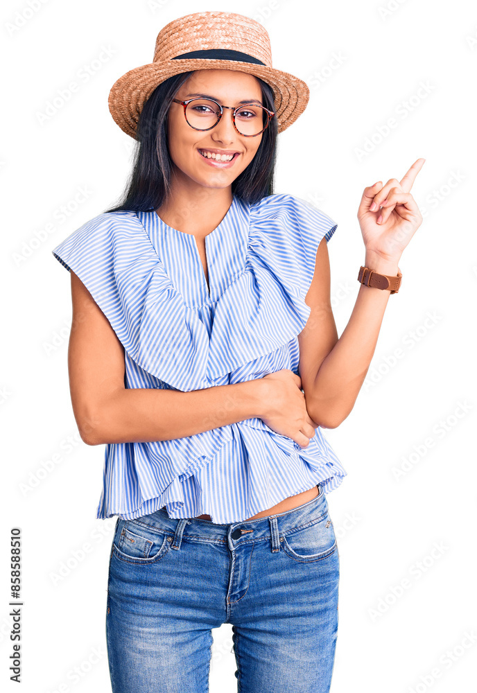 Sticker Young beautiful latin girl wearing summer hat and glasses smiling happy pointing with hand and finger to the side