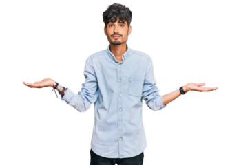 Young hispanic man wearing casual clothes clueless and confused expression with arms and hands raised. doubt concept.