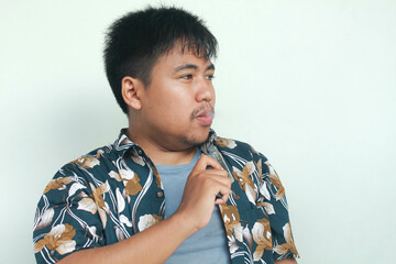 Young Asian man holding a vape or e-cigarette vaping device. quitting smoke concept.