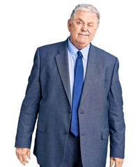 Senior grey-haired man wearing business jacket winking looking at the camera with sexy expression,...