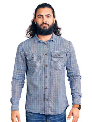 Young arab man wearing casual clothes relaxed with serious expression on face. simple and natural looking at the camera.